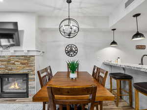 Dining space featuring wood finished floors, a fireplace, and a chandelier