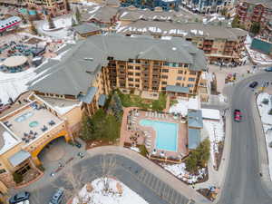 Snowy aerial view featuring view of pool area