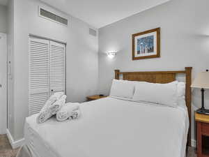 Carpeted bedroom with a closet and baseboards