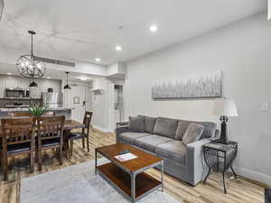 Living area featuring recessed lighting, light wood-type flooring, and a chandelier