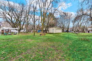 View of grassy yard featuring an outbuilding