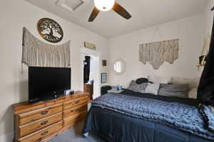 Carpeted bedroom with a ceiling fan