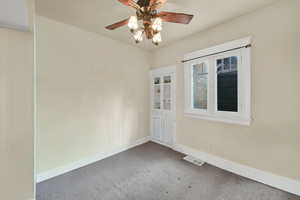 Empty room featuring carpet and ceiling fan
