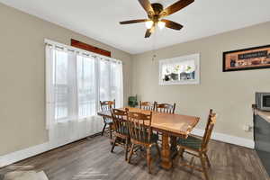 Dining space with dark wood-type flooring and a ceiling fan