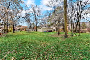 View of grassy yard featuring an outbuilding