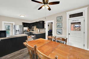 Dining area featuring dark wood-type flooring and a ceiling fan