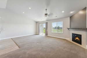 Unfurnished living room featuring light colored carpet, wood finish floors, a tile fireplace, recessed lighting, and a ceiling fan