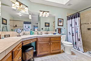 Full bath featuring vanity, a tile shower, and a textured ceiling
