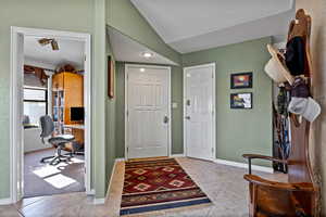 Entrance foyer with a textured wall, light tile patterned floors, and a textured ceiling