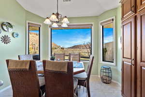 Dining room with a mountain view, a chandelier, plenty of natural light, and light tile patterned floors