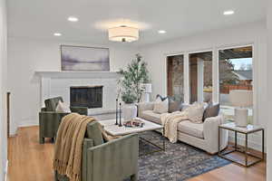Living area with a fireplace, recessed lighting, and light wood-style flooring