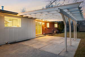 Patio terrace at dusk featuring a pergola and a patio