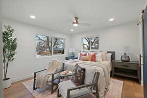 Bedroom with a ceiling fan, light wood-style flooring, multiple windows, and recessed lighting