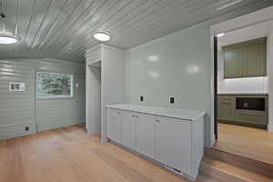 Additional living space featuring wood ceiling, vaulted ceiling, light wood-style flooring, and wooden walls
