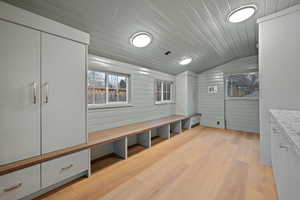 Mudroom featuring wood walls, wood ceiling, lofted ceiling, light wood-type flooring, and healthy amount of natural light