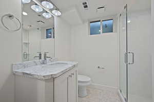 Full bathroom with vanity, a shower stall, and light tile patterned floors
