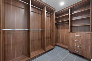 Walk in closet featuring elevator and dark tile patterned floors