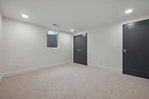 Basement featuring recessed lighting and light carpet