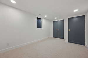 Finished below grade area with light carpet and recessed lighting