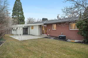 Back of house with a patio, a chimney, board and batten siding, brick siding, and french doors