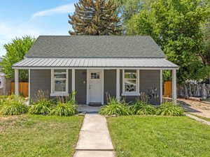 Bungalow-style home featuring covered porch and roof with shingles