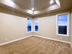 Carpeted spare room featuring baseboards
