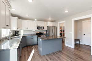 Kitchen featuring gray cabinetry, dark stone countertops, white cabinets, stainless steel appliances, and recessed lighting
