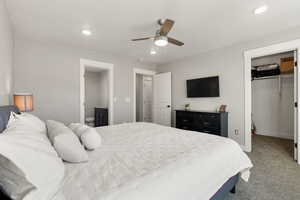 Primary bedroom featuring a walk-in closet, ceiling fan, connected bathroom, and recessed lighting