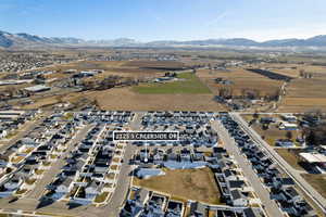 Aerial view of property and surrounding area with nearby suburban area and mountains