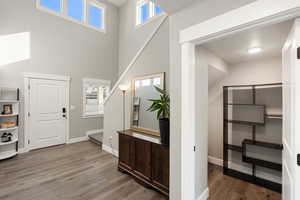Foyer entrance featuring light wood finished floors and a towering ceiling