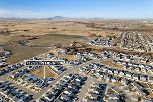 Aerial view of property's location featuring nearby suburban area, a mountainous background, and rural landscape