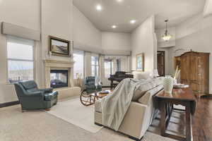 Living area with a multi sided fireplace, vaulted ceiling, and recessed lighting