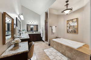 Full bath with vanity, a garden tub, vaulted ceiling, a tile shower, and light tile patterned floors