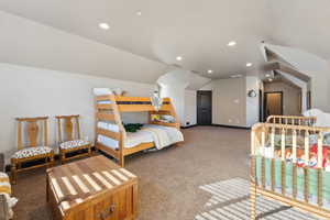Bedroom with light colored carpet, vaulted ceiling, and recessed lighting