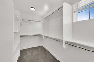 Walk in closet featuring dark carpet