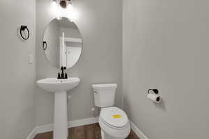 Bathroom with baseboards and dark wood-style floors