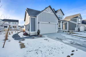 View of front of home with board and batten siding and driveway