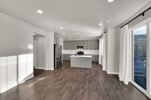 Kitchen featuring gray cabinets, a kitchen island, recessed lighting, stainless steel appliances, and dark wood finished floors