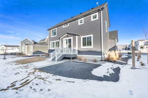 Snow covered back of property featuring a residential view
