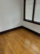 Unfurnished room featuring dark wood-type flooring and baseboards