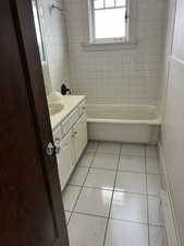 Bathroom featuring vanity, light tile patterned floors, and shower / bath combination