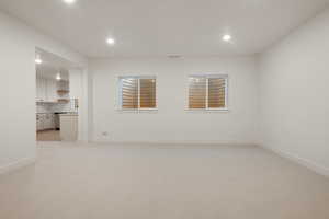 Unfurnished room with light colored carpet and recessed lighting