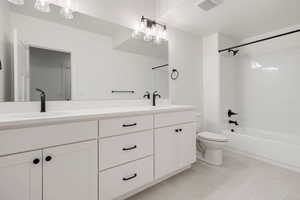 Bathroom featuring double vanity and bathtub / shower combination