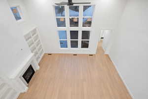 Unfurnished living room with light wood finished floors and a fireplace