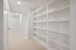 Hallway with light colored carpet and recessed lighting