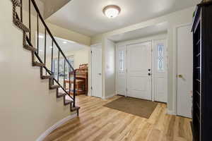 Foyer featuring light wood-style flooring, stairway, and recessed lighting