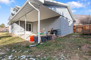 Back of property featuring a fenced backyard, a patio area, brick siding, and a chimney