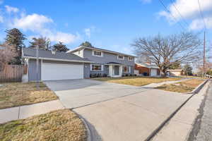 View of front of house with brick siding, concrete driveway, and a garage