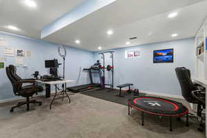 Office with light carpet and recessed lighting