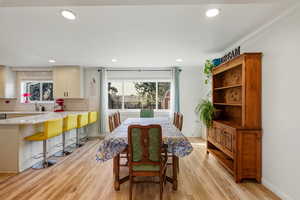 Dining room with light wood-style flooring and recessed lighting